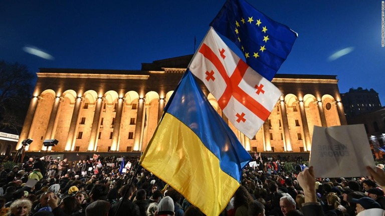 ジョージアの旗とともに、ウクライナや欧州連合の旗を掲げるデモ参加者＝８日、トビリシ/Vano Shlamov/AFP/Getty Images
